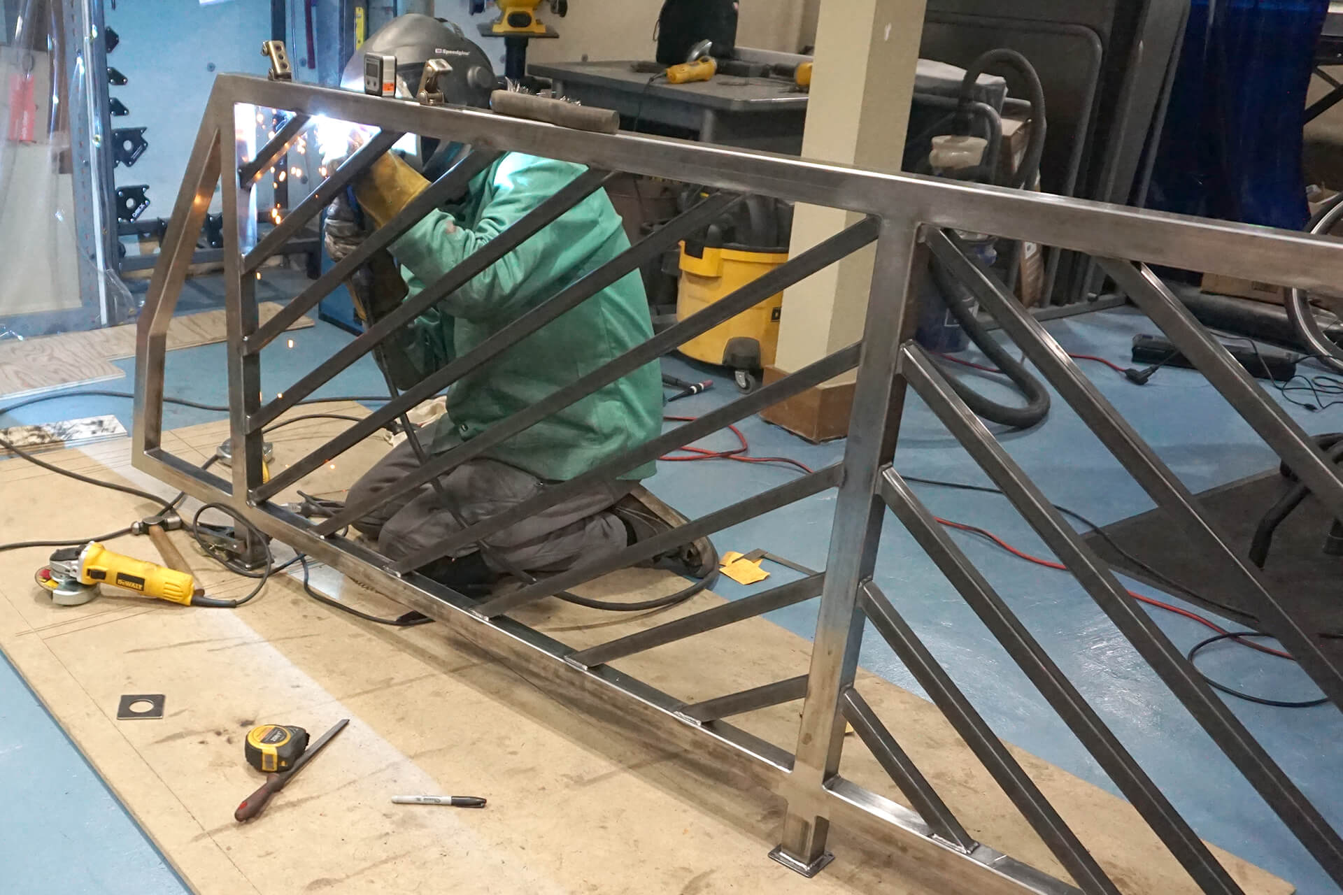 Welding the railing's angled balusters.