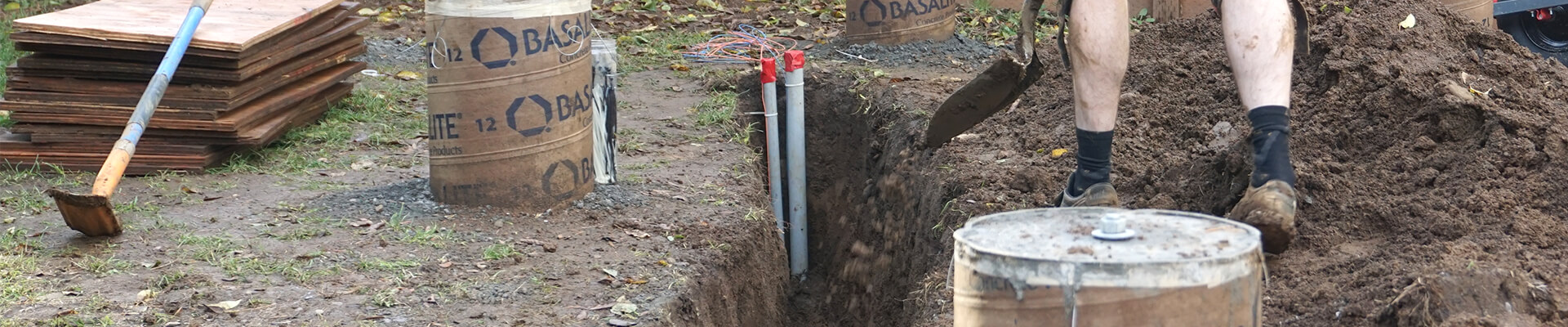 A close-up view of utility stub-outs in a trench.