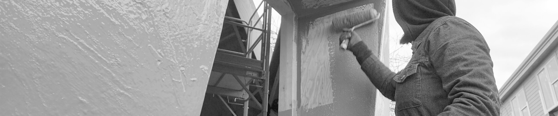 A close-up view of a person rolling a fluid-applied weather resistant barrier onto the dome sheathing.