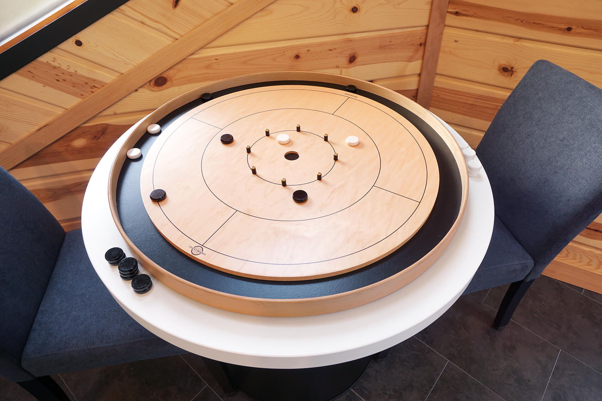 Crokinole board game set up on the dining room table, mid-game.