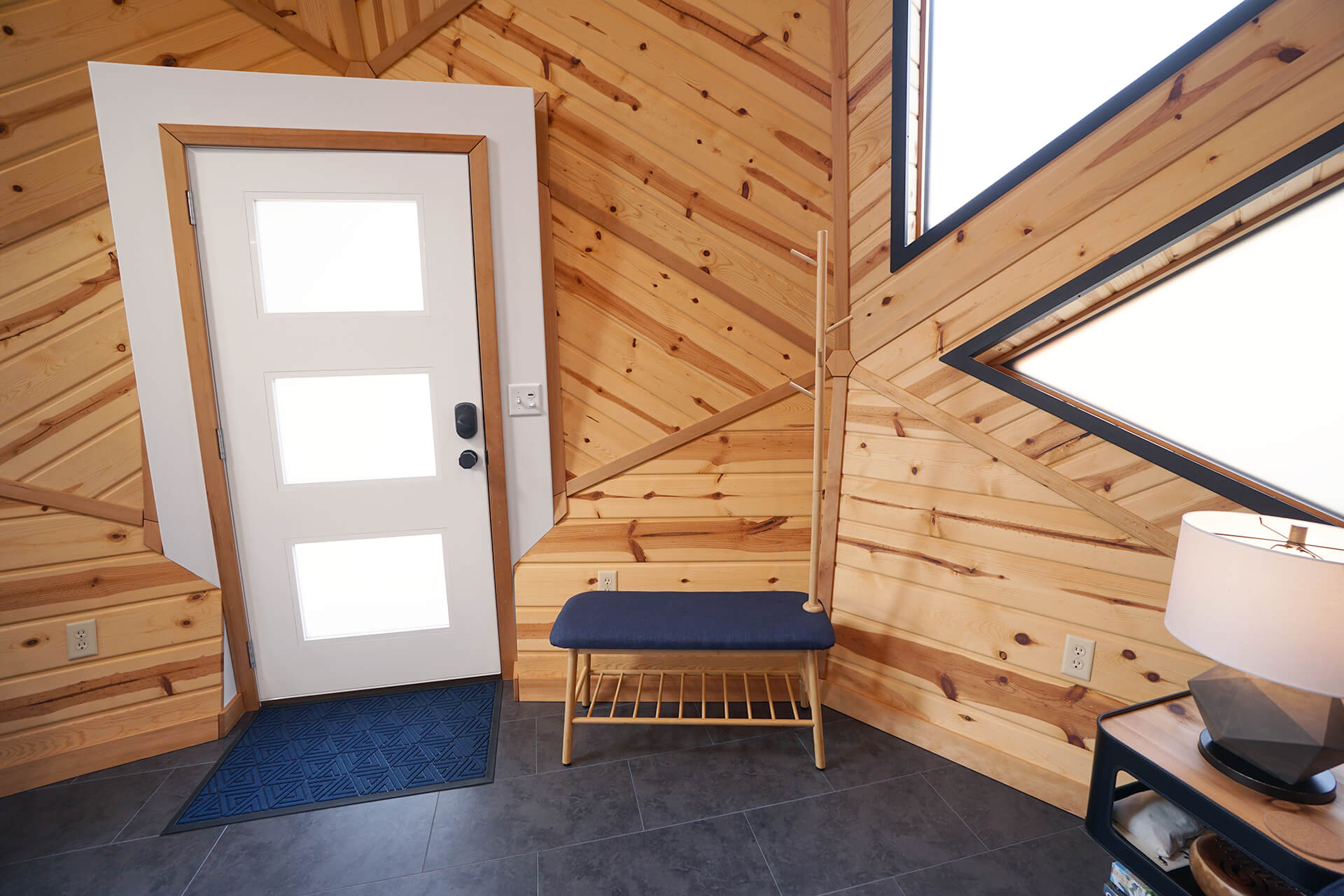 View of the bench and coat rack area, alongside the entrance.