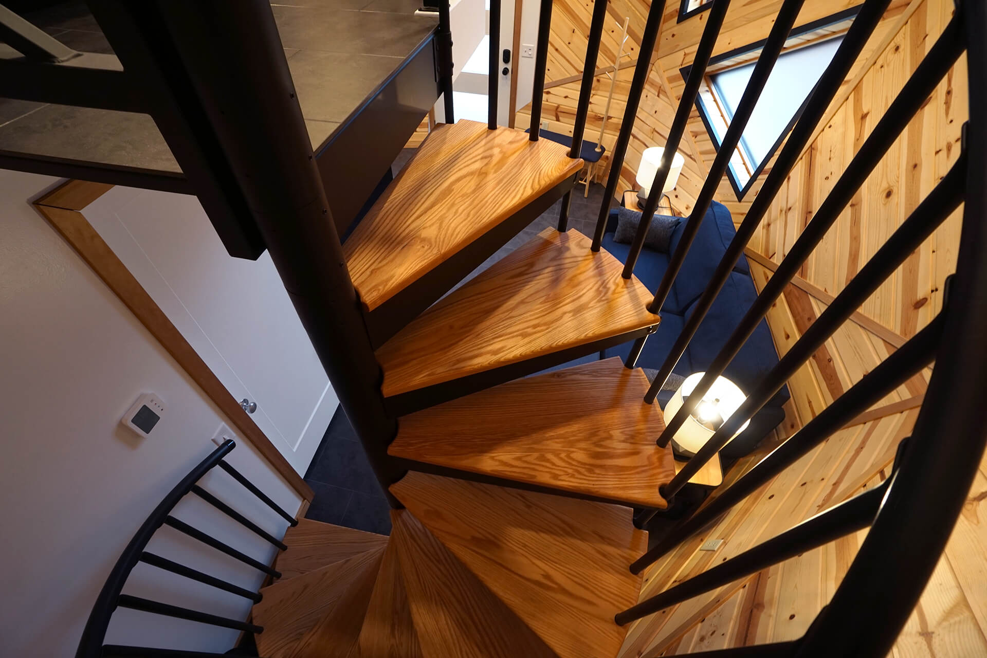 View from midway up the spiral stairs, looking toward the loft and down into the living space below.